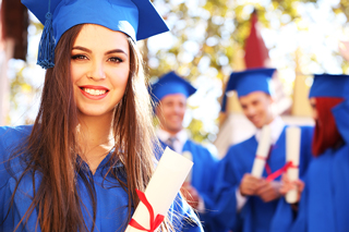 Women in a blue graduation cap and gown holding a diploma